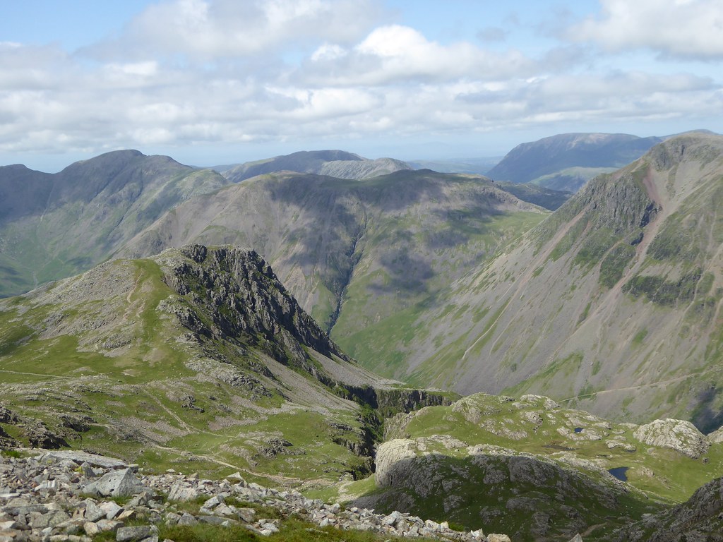 Scenic view of rugged mountain peaks under a partly cloudy sky in the Lake District, England
