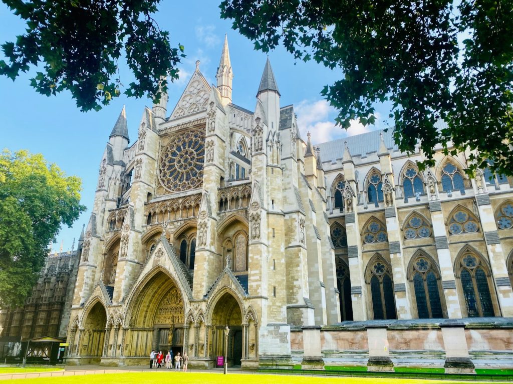 Gothic architecture of Westminster Abbey on a sunny day with green trees in London