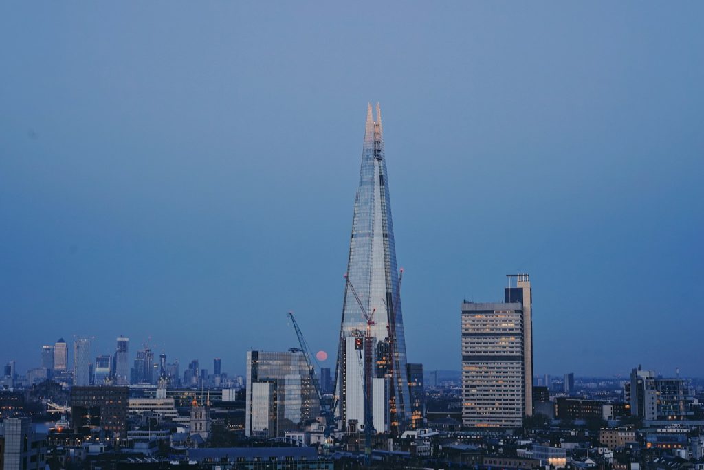 View of The Shard skyscraper in London skyline at dusk with clear sky and surrounding buildings